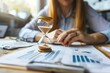 © Tanu - A dedicated professional reviews analytical charts and reports on a wooden desk, with an hourglass symbolizing the passage of time nearby, enhancing the momentâ€™s urgency.
