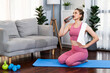 © Summit Art Creations - Athletic and sporty woman drinking water on fitness mat after finishing home body workout exercise session for fit physique and healthy sport lifestyle at home. Gaiety home exercise workout training.
