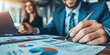 © stockmotion - Geschäftsmann analysiert und bespricht Finanzberichte und Diagramme im Büro