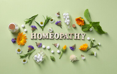 Wall Mural - Word Homeopathy, pills and medicinal herbs on olive background, flat lay