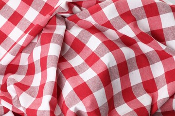 Crumpled checkered tablecloth as background, top view