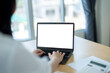 © Wasana - Businesswoman working with laptop computer with blank screen for advertisement