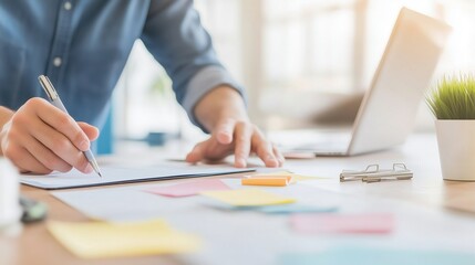 Wall Mural - Focused workspace scene showing a person writing on paper, emphasizing productivity and organization.