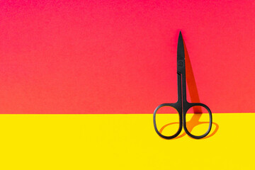 Wall Mural - Black Scissors on Bright Red and Yellow Background - Minimalist Design and Color Contrast