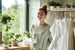 © kitipol - A young woman standing by a drying rack, hanging clothes with care and a smile, enjoying the peaceful routine of doing laundry at home