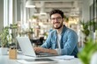 © kitipol - High-resolution brightly lit photorealistic candid photograph of a young marketer enjoying a productive workday on his laptop in a well-lit, airy office. The photograph is styled like a high-end