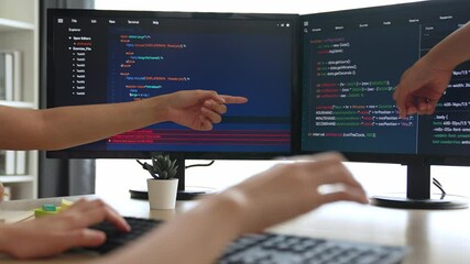 Slow motion back end software developer engineer for computer programming working together on debugging writing computing code, solving complex algorithms display on monitor in office. Burgeoning