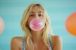© volga - Casual blond woman blowing pink bubble gum balloon