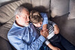 © Halfpoint - Boy and grandpa sleeping on sofa. Grandfather spending time with grandson, taking care of him while parents are at work.