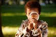 © AnnaStills - African American boy using magnifier to examine chanterelle while gathering mushroom in wood