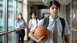 © Htet Wai Phyo - Indian High school student with basketball walking through hallway.