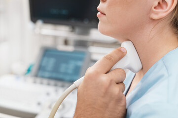 woman receiving thyroid diagnostics doctor's hand with sensor in rubber glove closeup. Treatment of thyrotoxicosis and hypothyroidism. Ultrasound diagnostics of endocrine system and thyroid gland