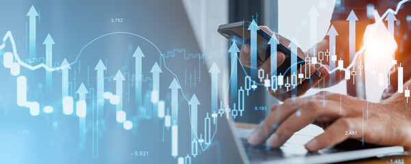 Wall Mural - Hands holding a phone and typing on a laptop with financial charts and upward arrows overlaying the scene. Blue and white background. Concept of business trends and growth