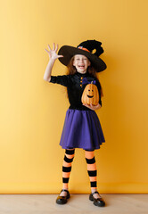 Wall Mural - girl in witch costume with Halloween pumpkin