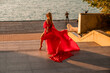 © svetograph - Sunrise red dress. A woman in a long red dress against the backdrop of sunrise, bright golden light of the sun's rays. The concept of femininity, harmony.