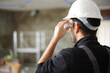 © Antonioguillem - Back view of construction worker putting protective glasses