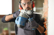 © Antonioguillem - Construction worker wrecking wall using rotary hammer