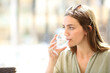 © Antonioguillem - Woman drinking water from cup in a bar