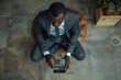 © Yuliia - An overhead shot of a young African businessman using a calculator to calculate finance bills in his office.