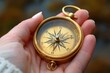© Yuliia - close-up photo of a female hand holding a golden compass, symbolizing navigation and exploration in business and maritime settings.