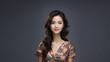 © KaRu's Gallery - A beautiful brunette Japanese businesswoman with neat hair and healthy skin smiles at the camera. She has natural makeup and is posing in a studio