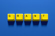 © Cagkan - Yellow computer keys spelling grant on blue background