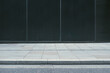 © yaqui_villegas - A minimalist photograph showing an empty sidewalk in front of a dark building wall, highlighting simplicity and the beauty of clean, uncluttered urban design.