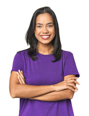 Wall Mural - young latina posing in studio who feels confident, crossing arms with determination.