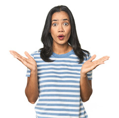 Wall Mural - young latina posing in studio surprised and shocked.