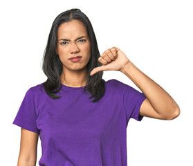 Wall Mural - young latina posing in studio showing thumb down, disappointment concept.
