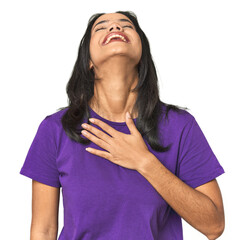 Wall Mural - young latina posing in studio laughs out loudly keeping hand on chest.