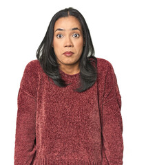 Wall Mural - simple portrait of a young latina shrugs shoulders and open eyes confused.