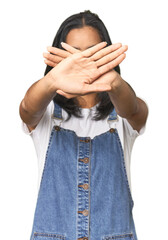 Wall Mural - simple portrait of a young latina doing a denial gesture