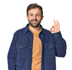 Studio portrait of young Hispanic male cheerful and confident showing ok gesture.