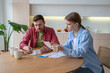 © DimaBerlin - Upset couple reviewing bills for rent, utilities, dealing with debts and overdue payments at home. Husband and wife address financial issues, accounting, inspecting papers, documents on coffee break
