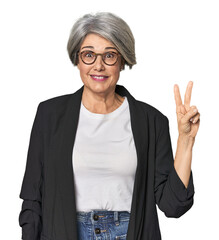 Caucasian mid-age female in business suit showing victory sign and smiling broadly.