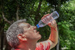 © kvdkz - Mature man drinking water from a bottle on a hot day