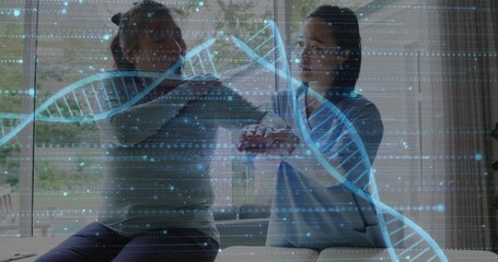 Wall Mural - Animation of dna strand and medical data processing over diverse female physiotherapist and patient