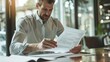 © venusvi - Focused businessman analyzing paperwork in a modern office
