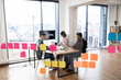 © Sofiia Shunkina - Group of IT experts working on developments in field of artificial intelligence. Brainstorming session with charts and sticky notes on glass wall in modern office environment.