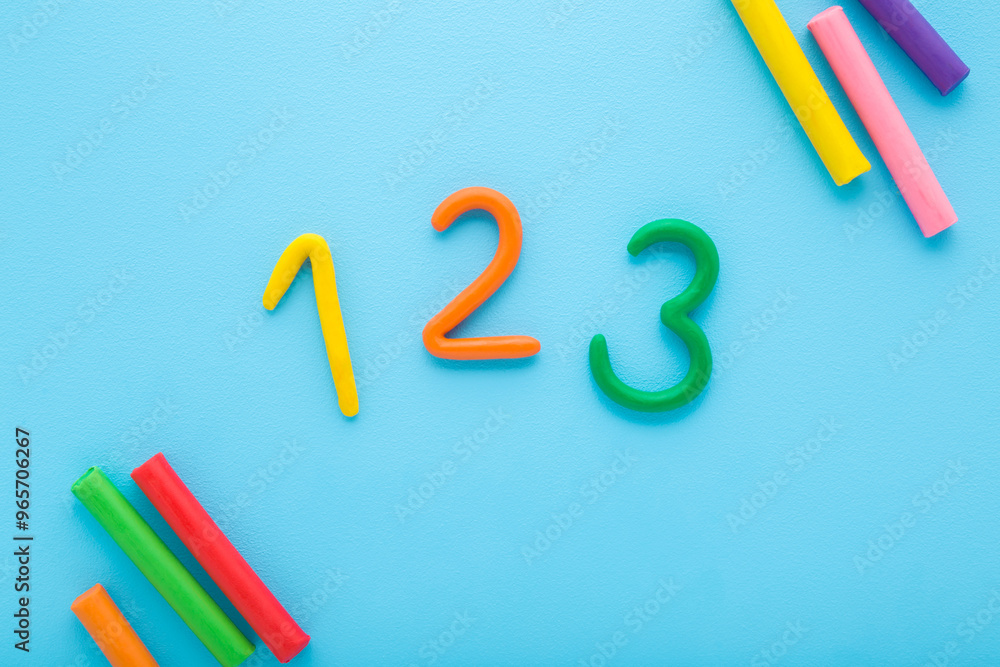 Colorful 123 numbers created from modeling clay on light blue table ...
