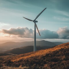 Sticker - A lone wind turbine stands tall on a grassy hilltop against a backdrop of mountains and a cloudy sky.