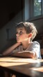 © RaptorWoman - A young boy sits thoughtfully in a sunlit room, gazing out the window, immersed in deep contemplation.
