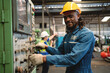 © KANGWANS - Africa American worker heavy industry worker engineer wearing safety suit Work in the background of an industrial factory.
