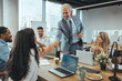 © Dragana Gordic - Business Meeting with Handshake and Laptops in Office