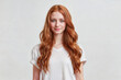 © NullByte Store - Closeup of happy attractive young woman with long wavy red hair and freckles wears stylish t shirt looks happy and smiling isolated over white background