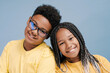 © Maria Vitkovska - Smiling African American kids bonding together looking at camera isolated on blue