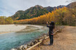 © Noppasinw - Nature landscape at Kamikochi Japan in autumn season with woman tourist taking photo
