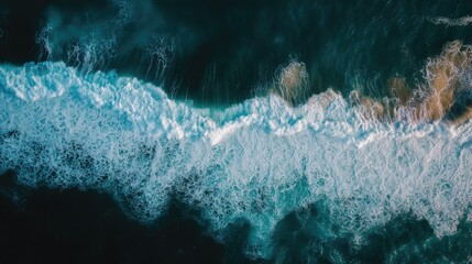 An aerial shot of ocean waves crashing on the shore in rhythmic motion, capturing the dynamic power of nature.