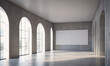 © Miklos - A large, empty room with arched windows and a blank canvas on the wall, perfect for showcasing art or design